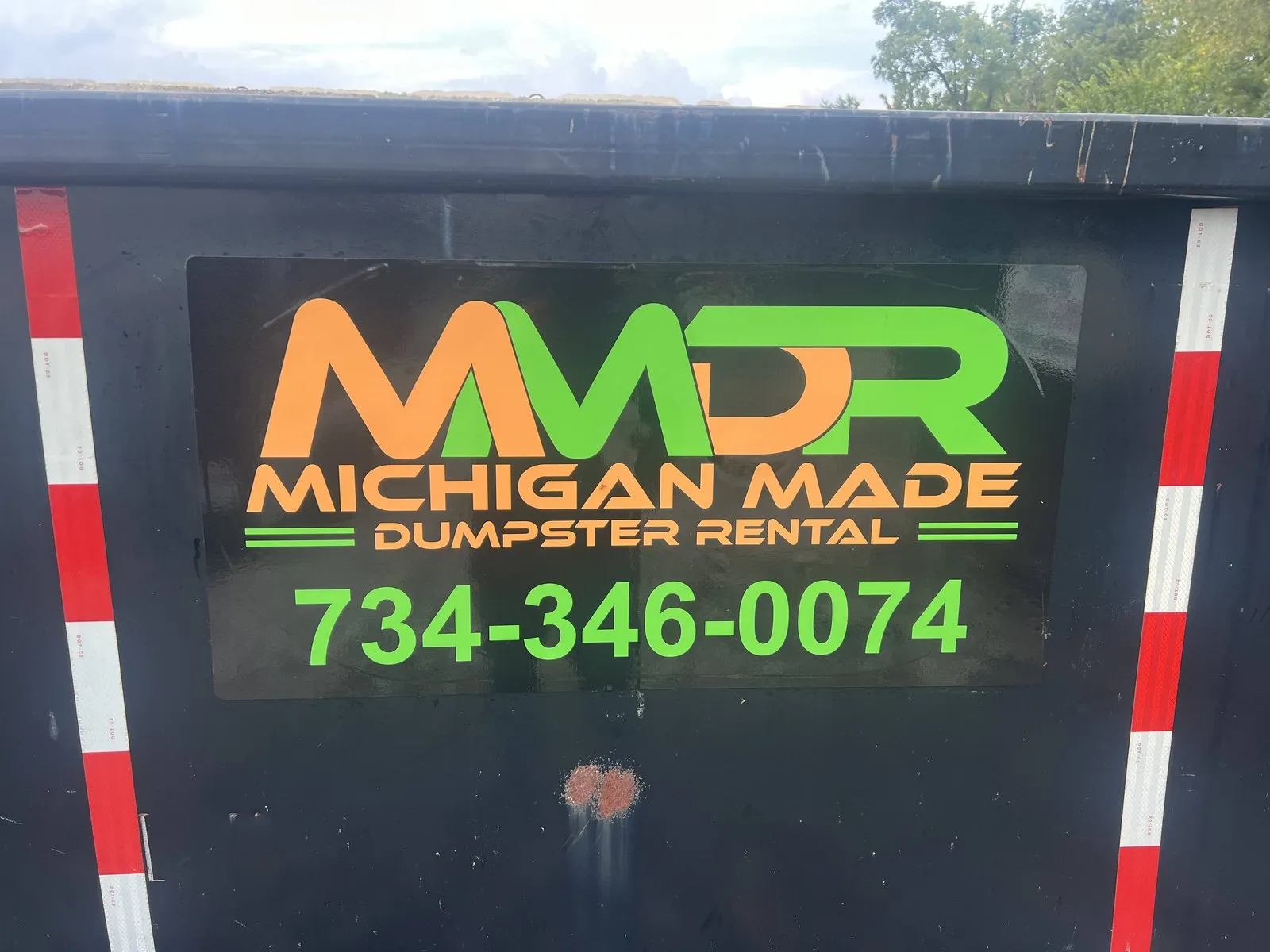 Michigan Made Dumpster Rental branded container showing the 734-346-0074 contact number